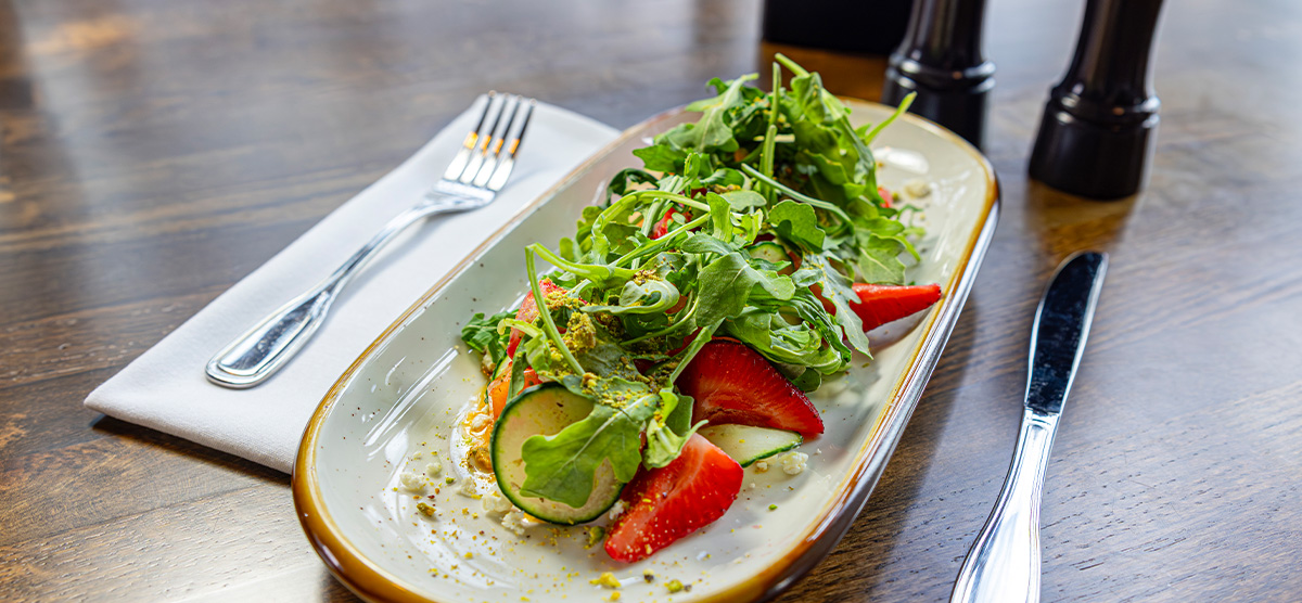 Melon Salad with sliced cantaloupe, chili lime vinaigrette, feta cheese, arugula, cucumber, strawberry, and pistachio.