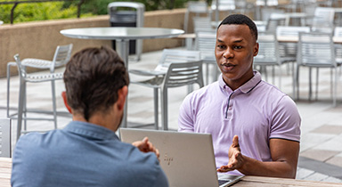 A Sentry intern having a conversation on the patio at the Sentry Insurance home office in Stevens Point.