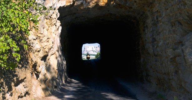 Tunnel in Iron Mountain Road with Mount Rushmore seen in distance.