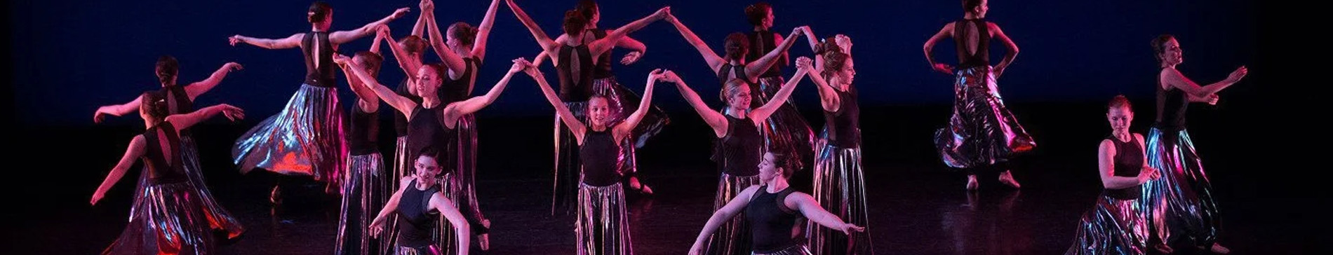Dancers on a stage dressed in black. 