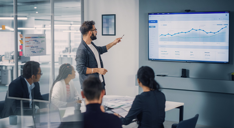 Man reviewing a chart with co-workers