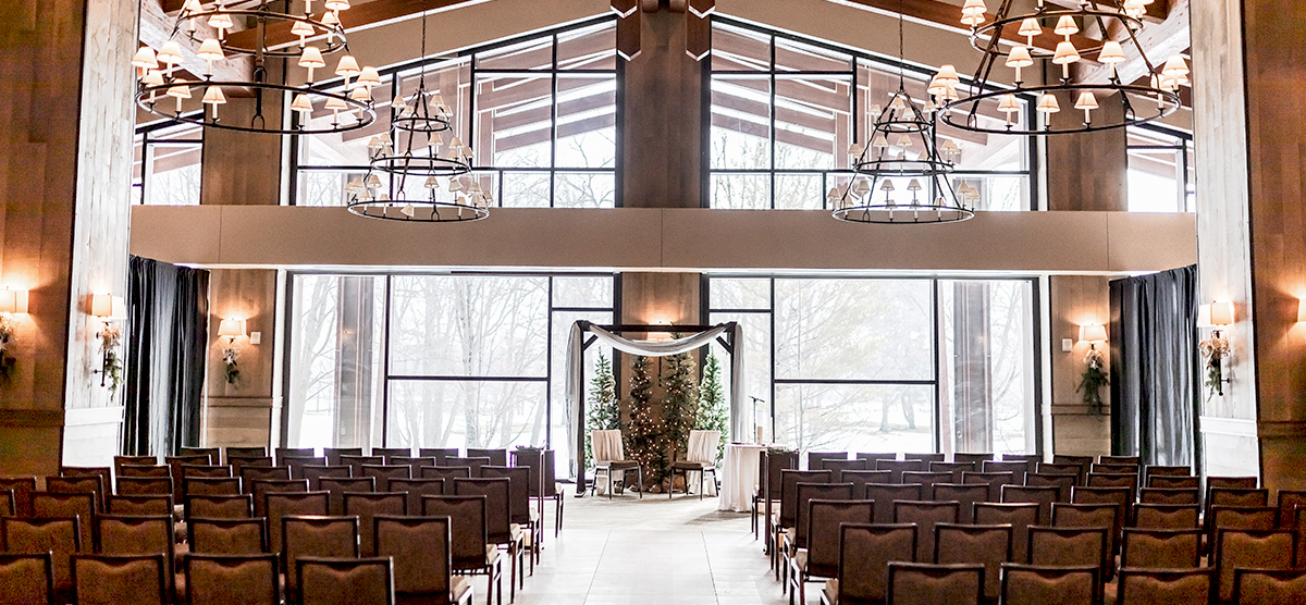 carousel-wedding-venue-grand-hall-5-1200x556 Rows of chairs set up in front of a wall of windows for a wedding ceremony in the grand hall.