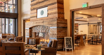 Chairs in front of a fireplace with cafe seating behind. 