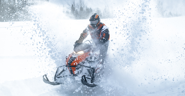 Snowmobile rider with snow flying