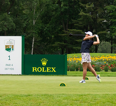 Junior girl golfer teeing off. 