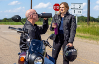 Two motorcycle riders drinking water