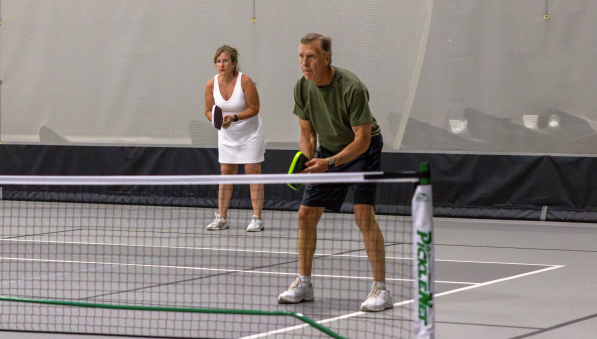 Two pickleball players play pickleball at the SentryWorld fieldhouse.