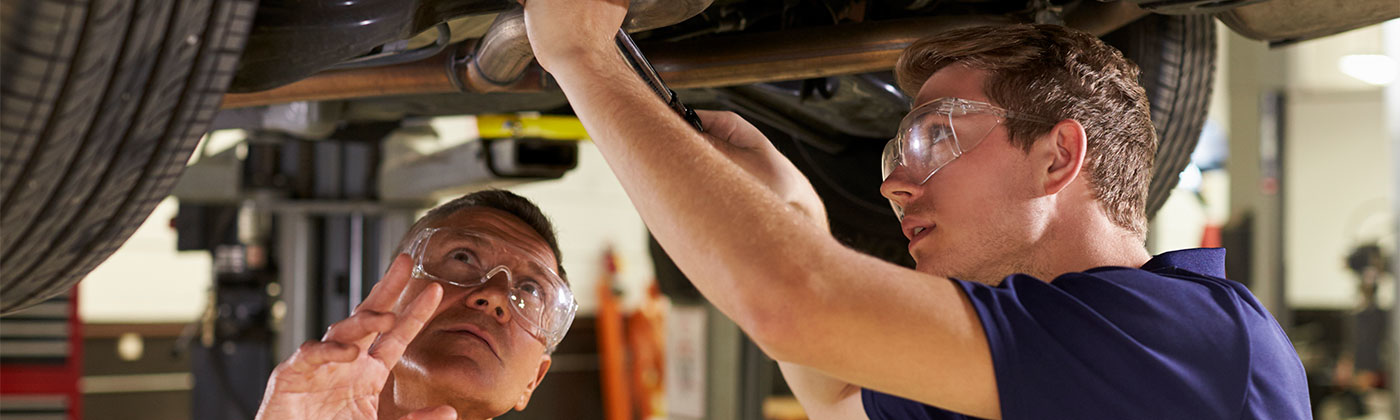 Two men working under a car