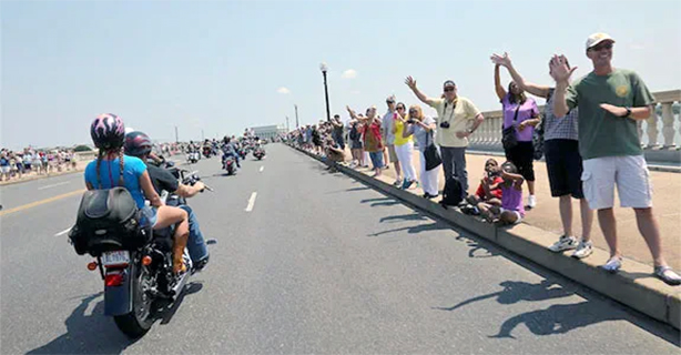 People waving at motorcycles in a parade