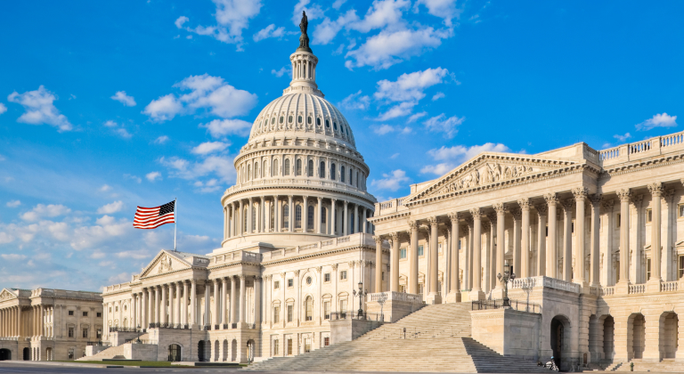 The U.S. Capitol building under a blue sky with scattered clouds.