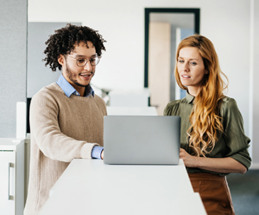 Man and woman standing reviewing laptop