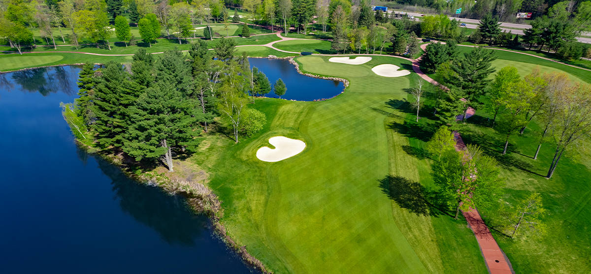 Aerial view of a fairway with sand traps and a large water hazard on the SentryWorld golf course