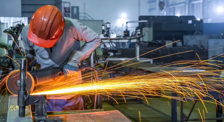 Welder in safety gear with sparks flying.
