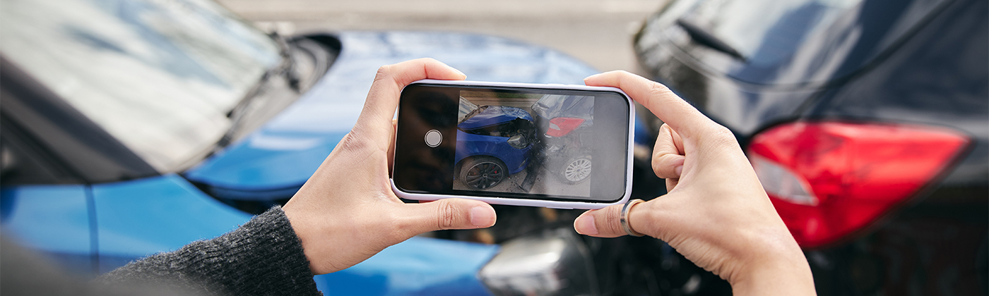 Person taking a photo of damage after a car accident.
