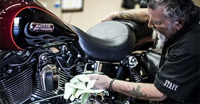 Man cleaning a Harley-Davidson motorcycle