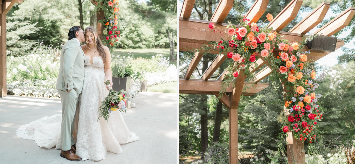 Groom kisses bride’s cheek under a flower-decorated pergola at an outdoor wedding.