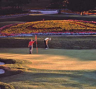 Two people putting on the 16th hole green at SentryWorld