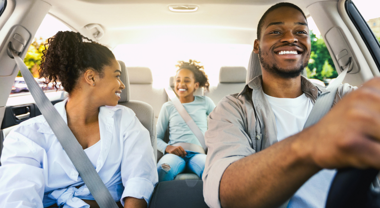 Happy family driving in their car.
