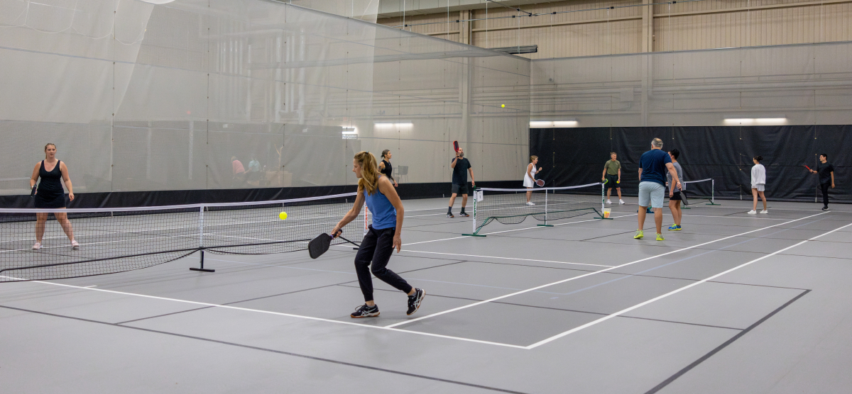 SentryWorld fieldhouse with multiple pickleball games being played. 