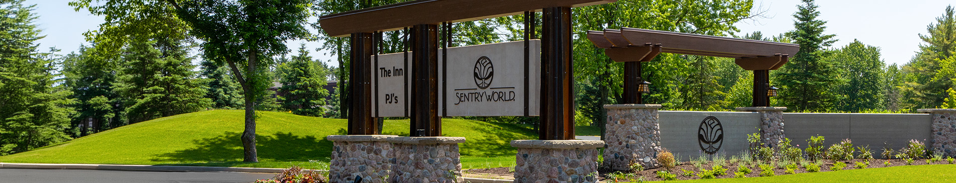 Entrance sign for SentryWorld with stone pillars and wooden beams.