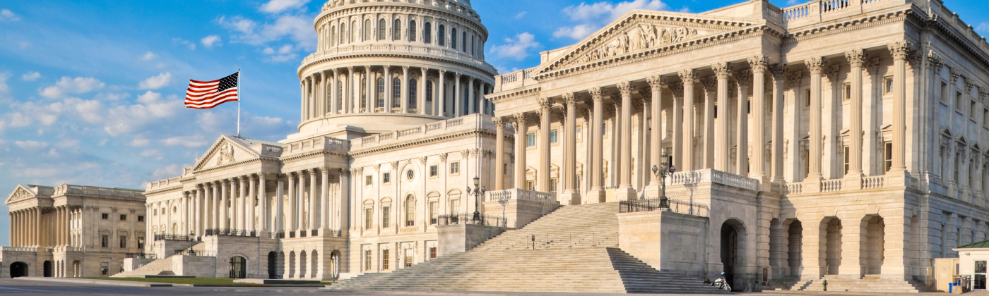 The U.S. Capitol building under a blue sky with scattered clouds.