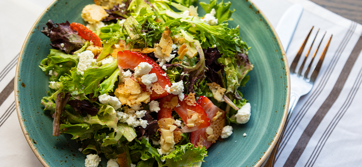 Salad with strawberries, croutons, and cheese on a plate