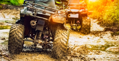 Two ATVs driving in mud