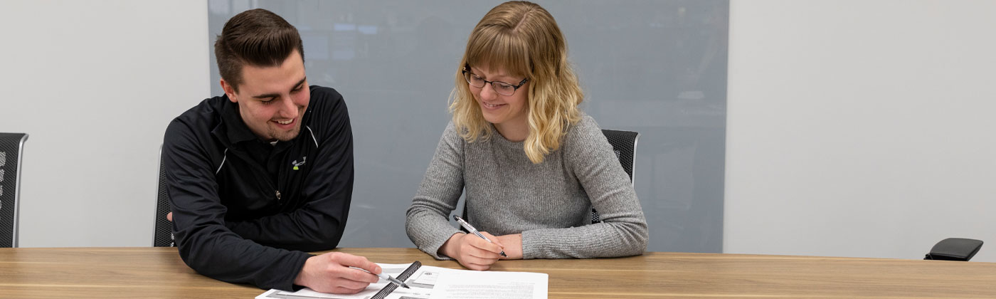 Two sentry employees looking at a binder