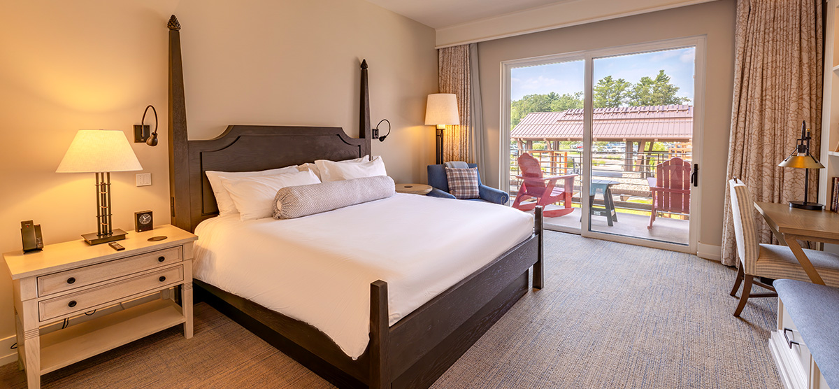 carousel-accessible-king-terrace-1-1200x556 King bed with patio door overlooking the hotel entrance.