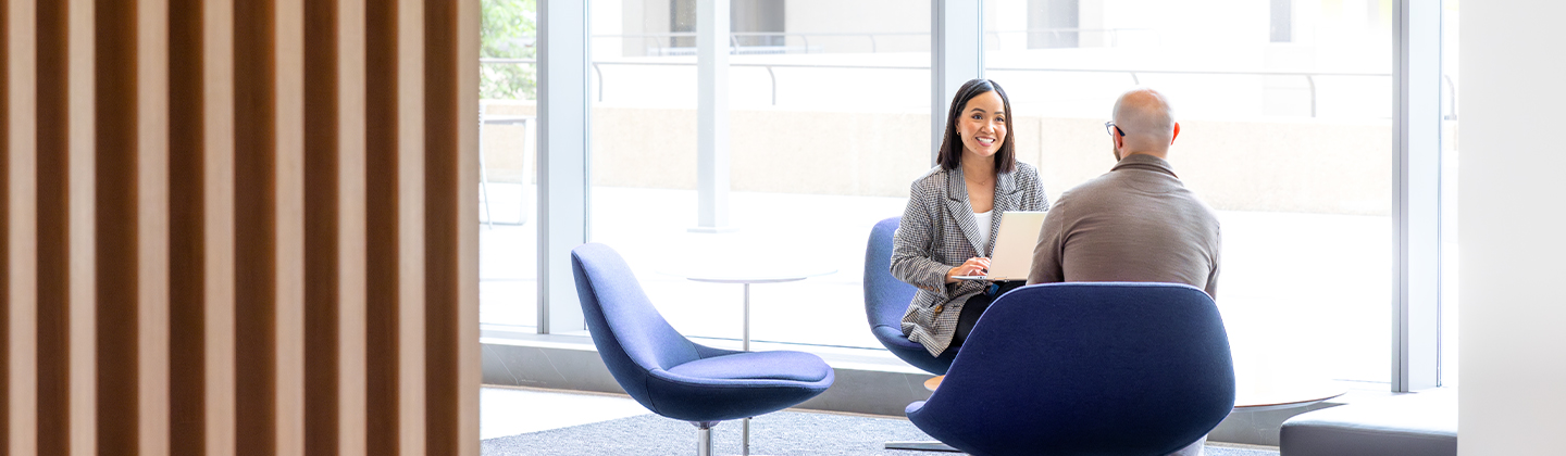 two people sitting and talking in an office setting