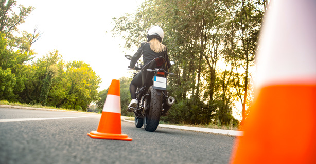 Motorcyclist navigating around traffic cones