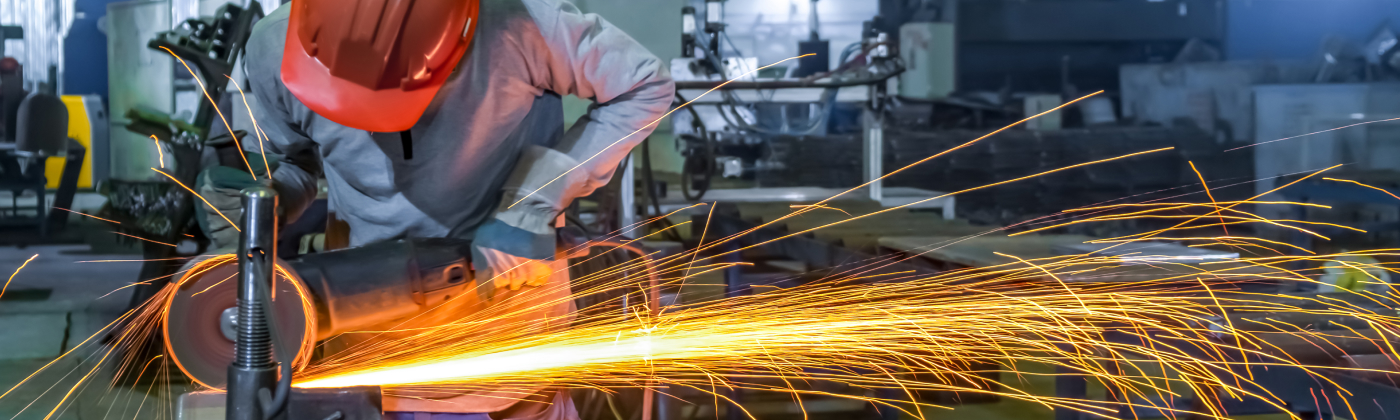 Welder in safety gear with sparks flying.
