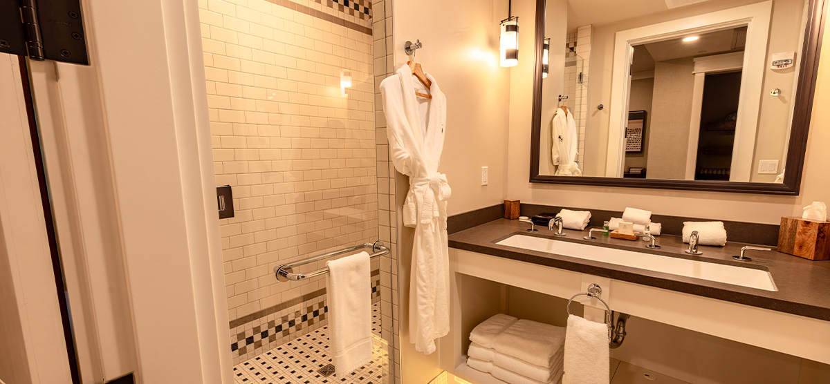 carousel-executive-queen-terrace-4-1200x556 Bathroom shower and sink area.