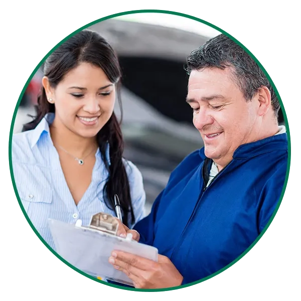 woman-getting-claims-service-circle-crop-LG Foto de una mujer y un hombre que tiene en sus manos un portapapeles con documentos que ellos están revisando acerca de reclamos y servicios de seguro de auto