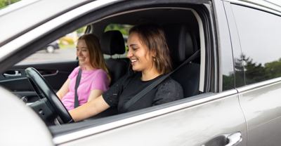 Two happy, young women in car together