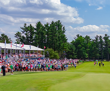 Fans standing along the 18th hole watching the 2023 U.S. Senior Open players golf