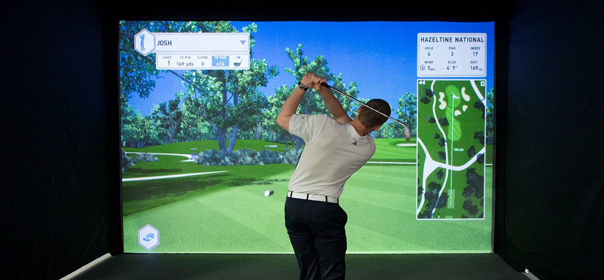 Golfer playing with the golf simulator in the SentryWorld fieldhouse