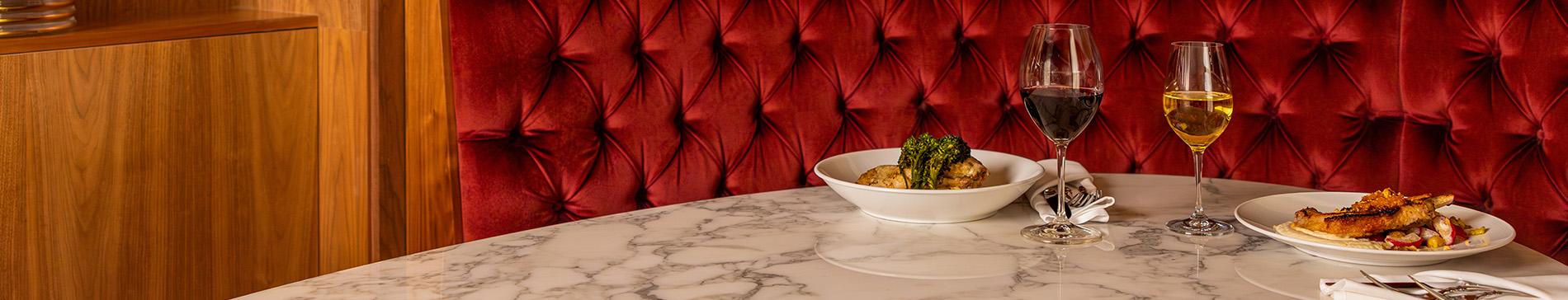 Marble table at Muse with two plates and two wine glasses. 