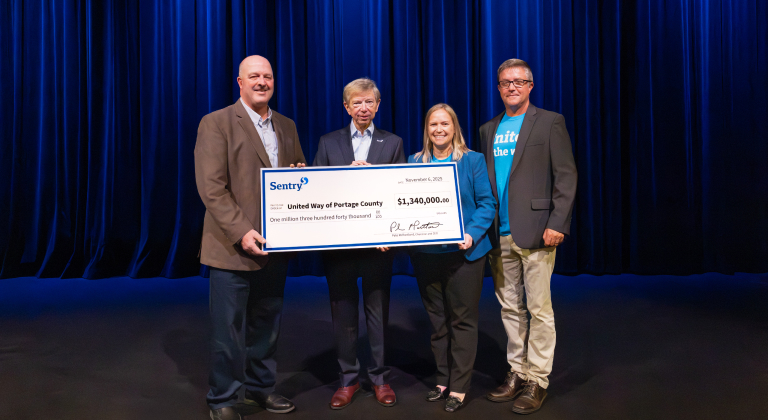 people holding a check on stage