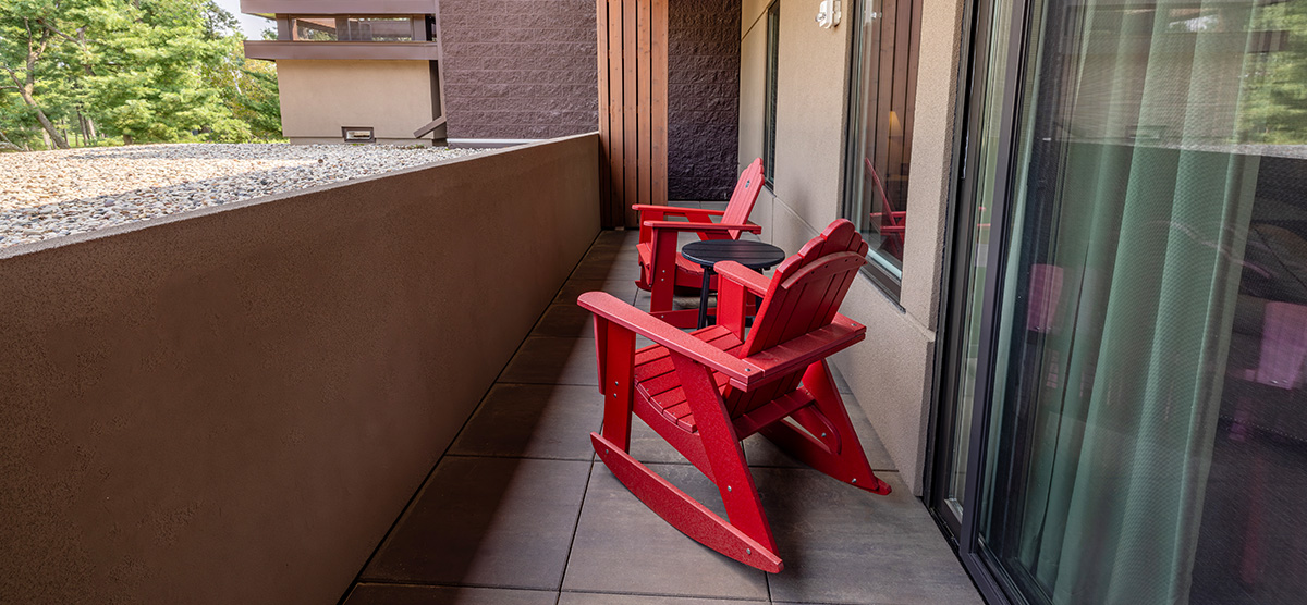carousel-accessible-golf-view-executive-junior-suite-7-1200x556 Terrace area with two red rocking chairs.