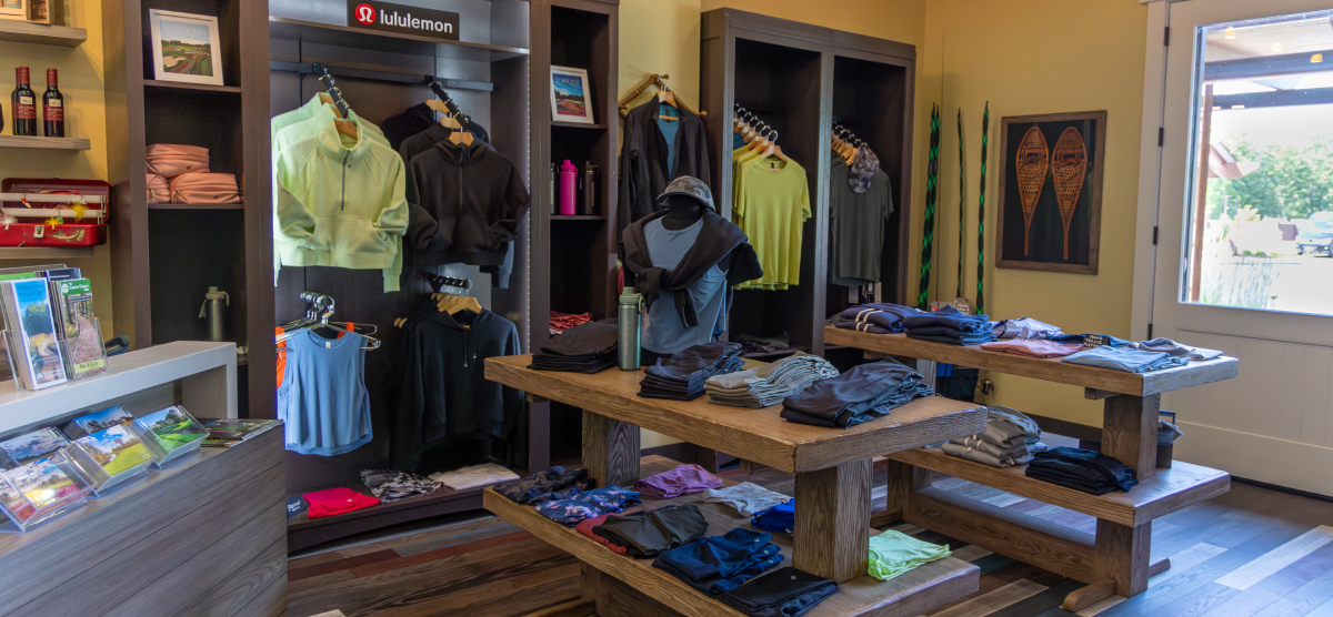 Retail display with a mannequin, hat, bags, and clothing items in a store.