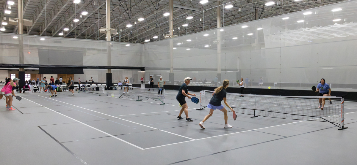 SentryWorld fieldhouse with multiple pickleball games being played. 