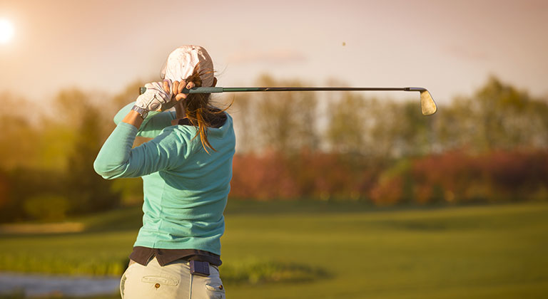 Woman swinging a golf club