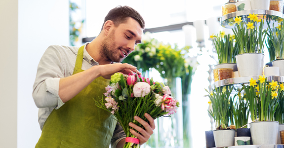 man working in a floral shop, arranging bouquet