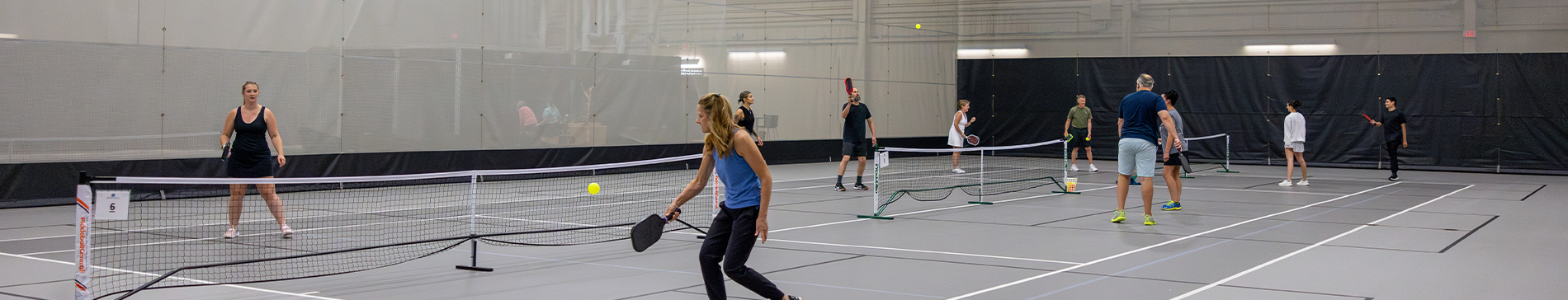 People playing pickleball in the fieldhouse at SentryWorld