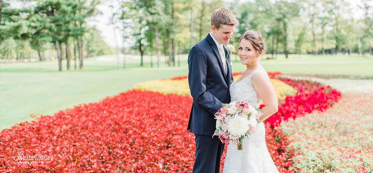 Groom and bride holding floral bouquet at the flower hole at the SentryWorld golf course