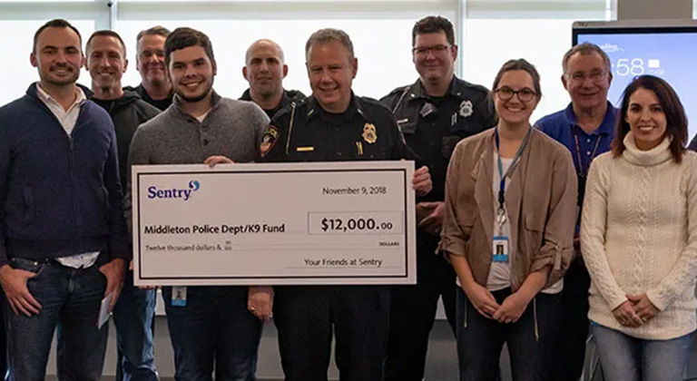 People with a check from Sentry for $12,000 for the Middleton Police Department K9 fund.