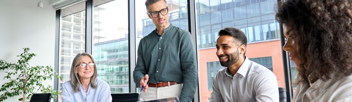 Four people in a meeting room in an office