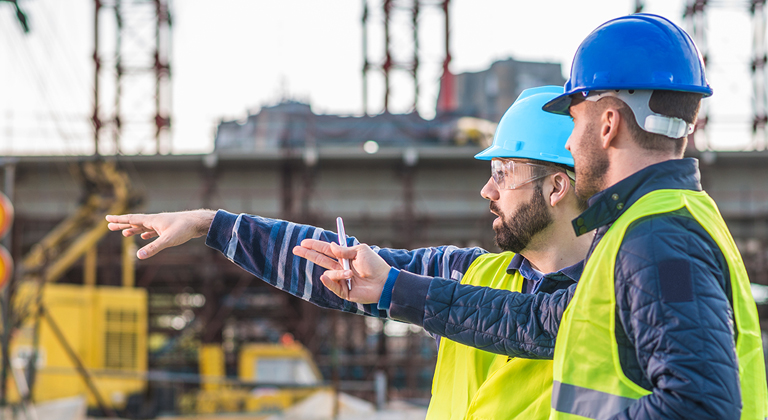 Two people in hard hats on construction site