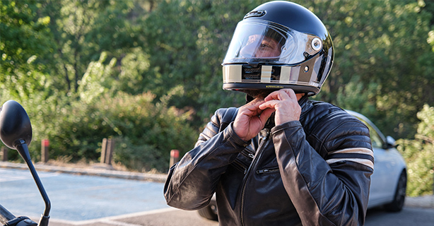 A biker puts on helmet before riding a motorcycle